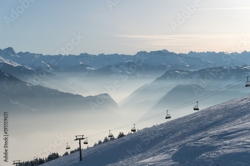 ski resort with ski slopes and lifts and a great view on a sunny winter day in the Alps