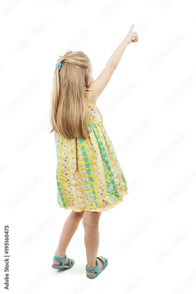 Back view of adorable little girl pointing at wall. Rear view. Isolated