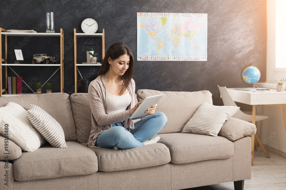 Obraz premium Young woman at home with tablet