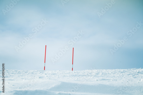 A beautiful white snowy road in central Norway with a red safety poles. Minimalist winter scenery un northern Europe.