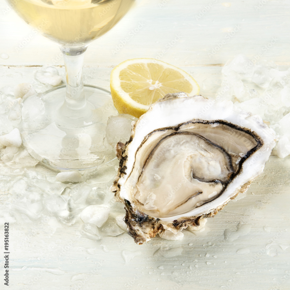 Obraz Closeup photo of an oyster with wine and lemon