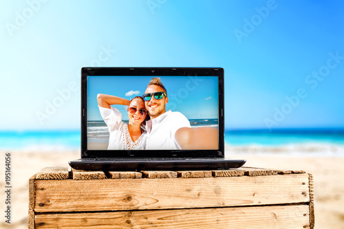 summer time and black laptop on beach 