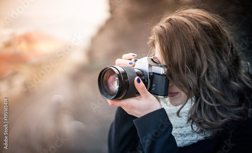Young woman girl photographer with blue camera lens