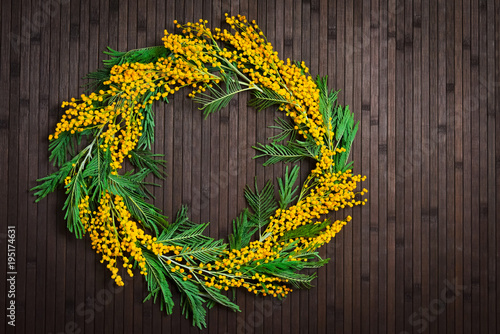 Wreath of mimosa on a brown background