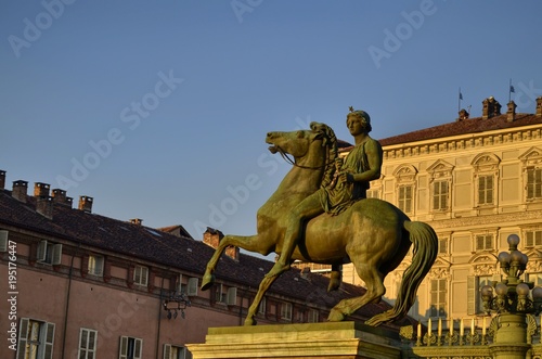 Turin, Italy, Piedmont, December 8 2017. The facade of the royal palace illuminated by the yellow light of the sun before sunset. In evidence the equestrian statue of Polluce. photo