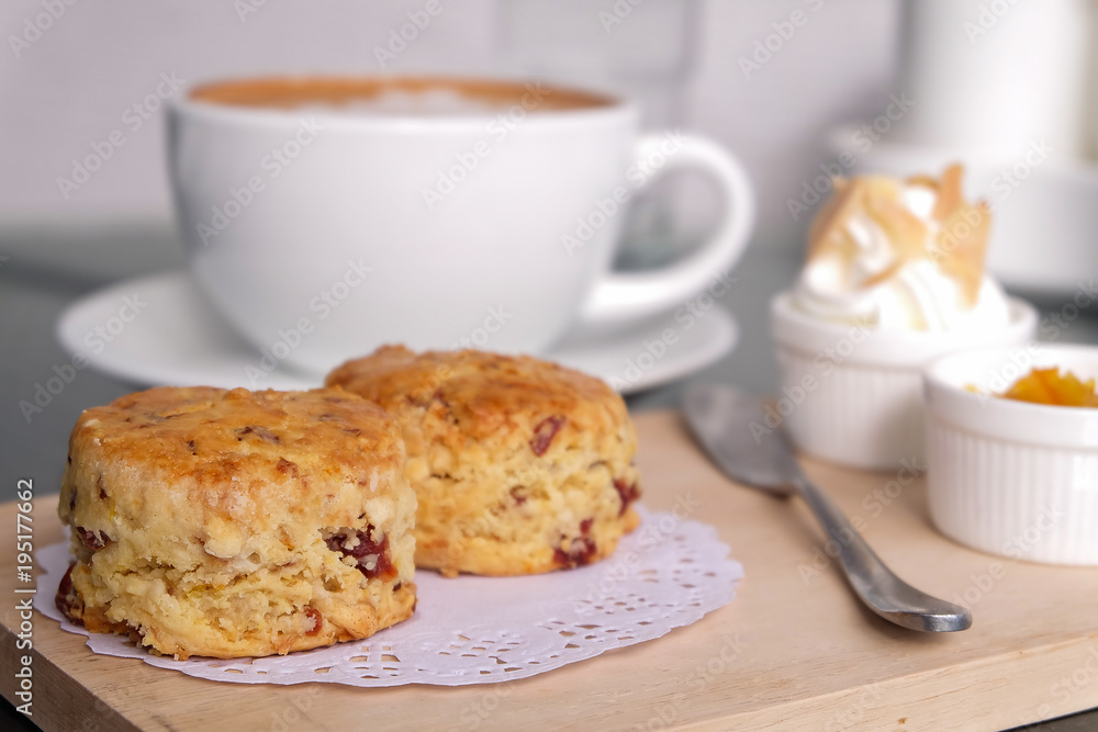Traditional delicious British pastry and dessert - eating scones with hot latte coffee. Traditional delicious British pastry and dessert - eating scones with hot latte coffee.