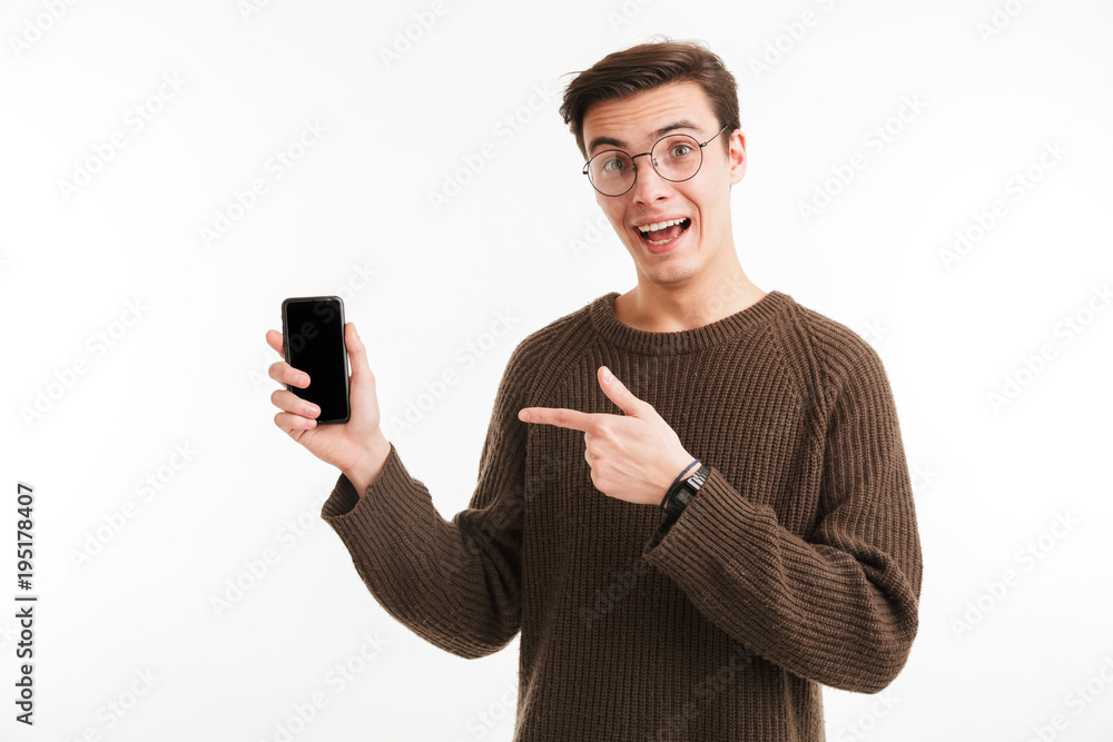 Portrait of an excited young man in sweater pointing finger