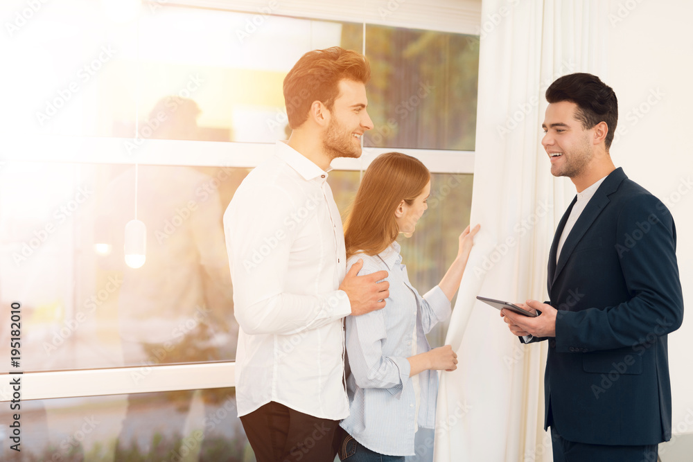 Young couple in a meeting with a realtor. Guy and girl make a contract with realtor buying property. Young couple in a meeting with a realtor. Guy and girl make a contract with realtor buying property.