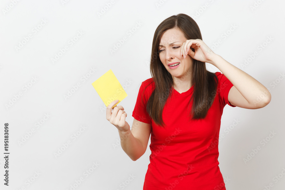 European upset crying shocked young woman, football fan or player in red uniform hold yellow soccer card for retire from field isolated on white background. Sport, play, healthy lifestyle concept. European upset crying shocked young woman, football fan or player in red uniform hold yellow soccer card for retire from field isolated on white background. Sport, play, healthy lifestyle concept.