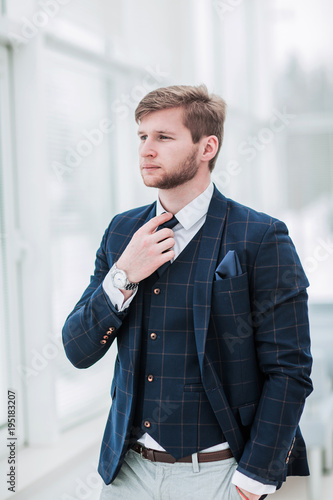 pensive newcomer businessman in a business suit stands near the 