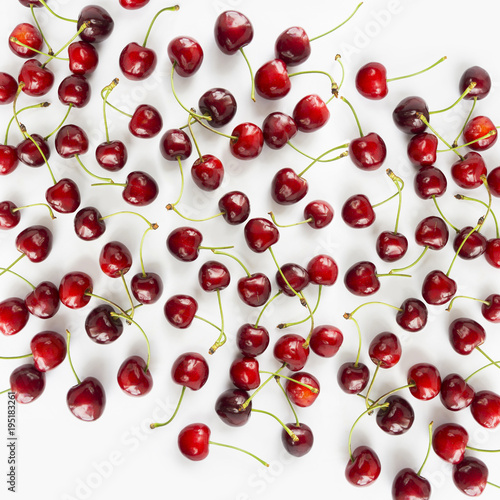 Fresh red cherries lay on white isolated background with copy space. Background of cherries. Ripe cherry on a white background. Cherries with copy space for text. Top view. 