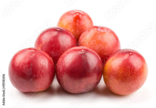 Six plums red orange isolated on white background like billiard balls triangle.