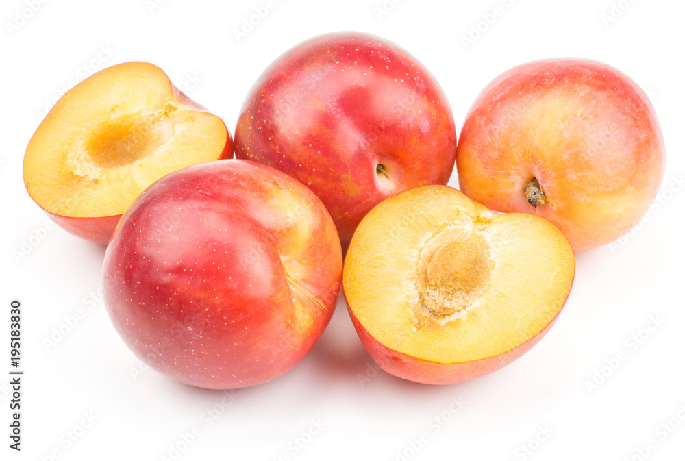 Three plums red orange and two halves isolated on white background fresh and glossy.