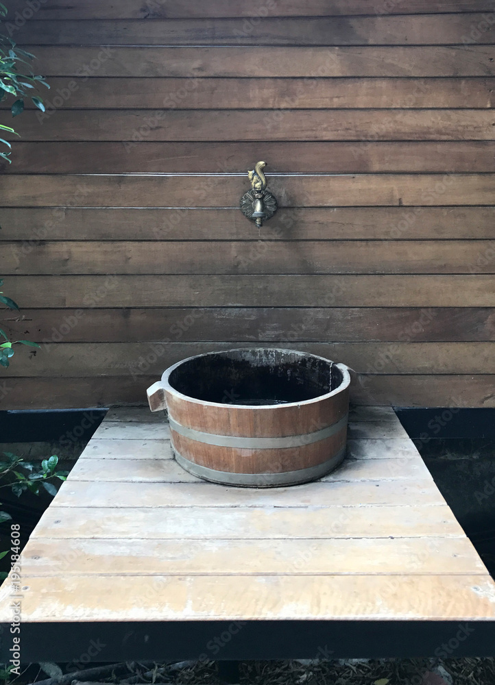 Classic wooden wash basin with brass faucet on wooden wall Classic wooden wash basin with brass faucet on wooden wall