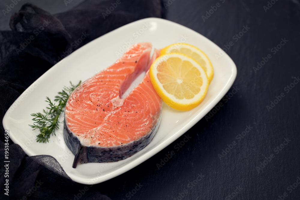 raw salmon with lemon on white dish