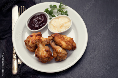 fried chicken with sauces on white plate