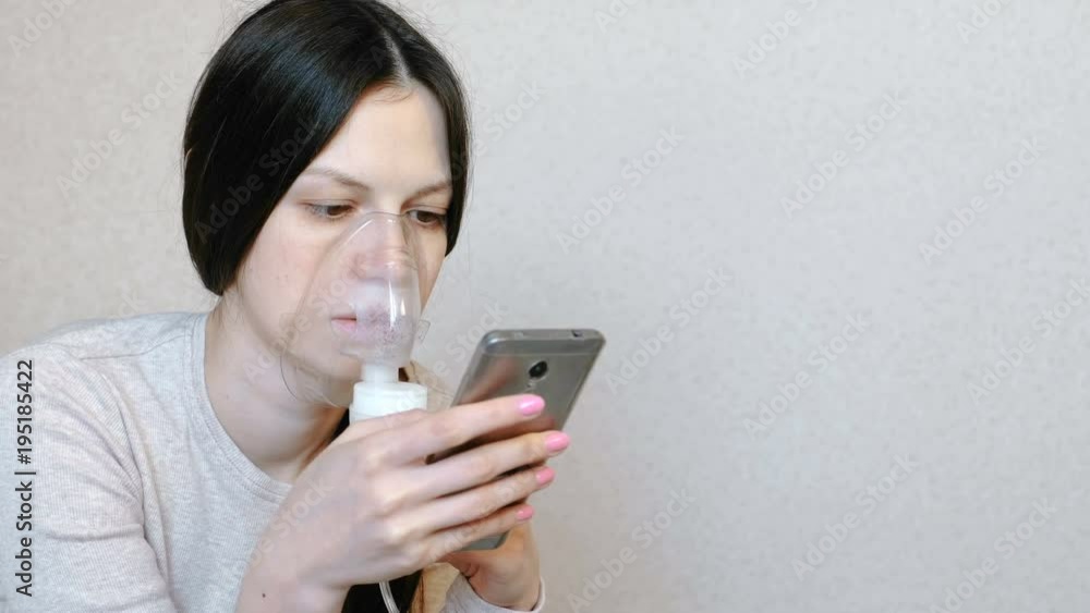 Use nebulizer and inhaler for the treatment. Young woman inhaling through inhaler mask. Side view. Use nebulizer and inhaler for the treatment. Young woman inhaling through inhaler mask. Side view.