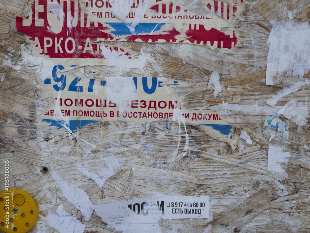 Old Street Billboard With Torn Peeled Poster Horizontal Background. Outdoor Bulletin Board Or Plywood Panel With Worn Advertising Message, Notice And Stickers Urban Texture. Abstract Creative Surface