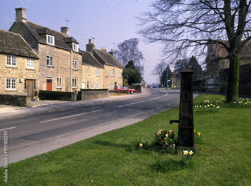 England, Gloucestershire, Cotswolds, Tetbury, Street scene, old water pump, spring flowers photo