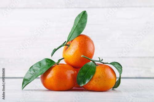 fresh ripe tangerines, rustic food photography on white wood plate kitchen table can be used as background © Kanea
