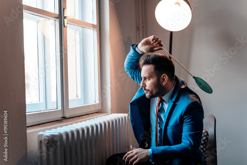 Fotografija Men in a suit hitting a fly with a fly swatter.