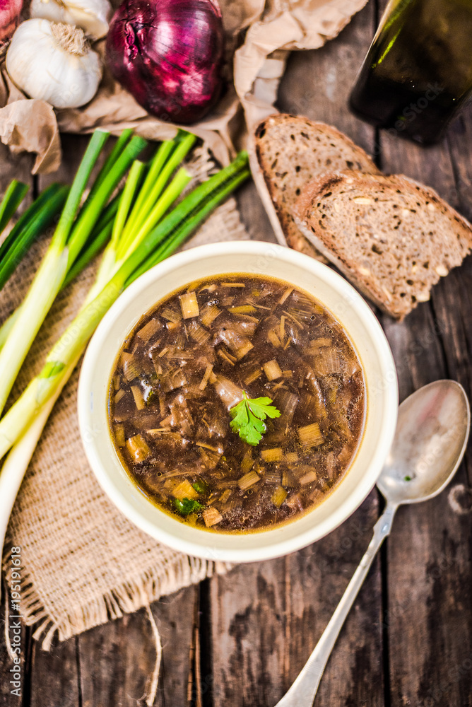 Homemade healthy french onion soup with plain toasted some bread top down view, on rustic wooden table. Homemade healthy french onion soup with plain toasted some bread top down view, on rustic wooden table.