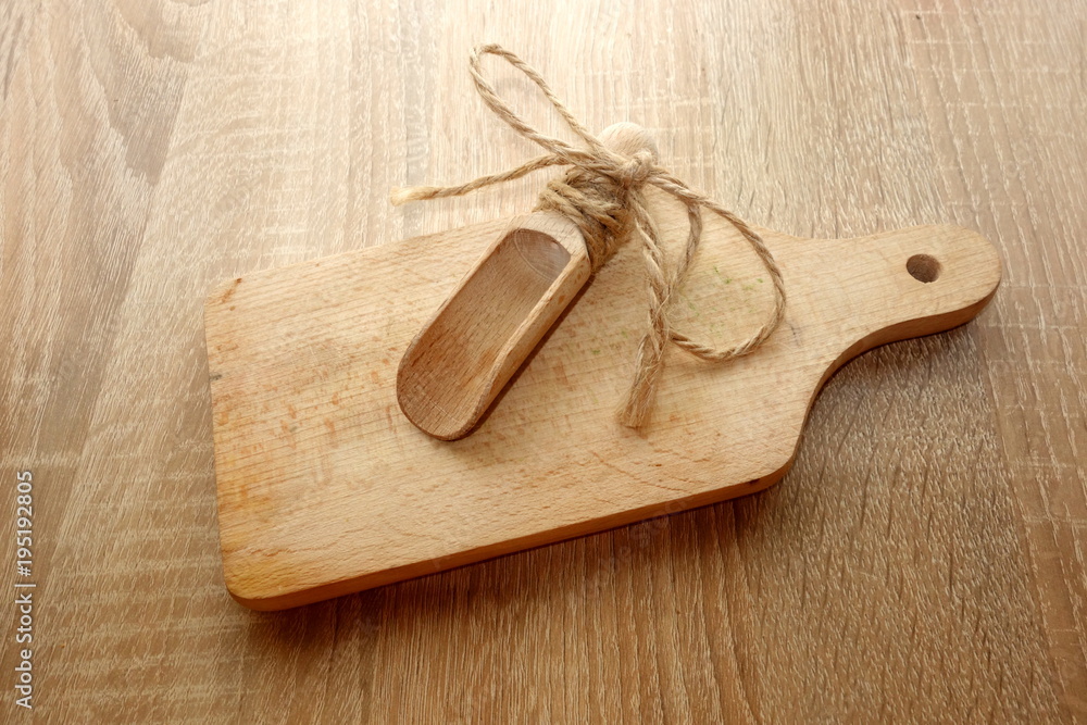 Wooden cutting board with spoon on rustic table Wooden cutting board with spoon on rustic table