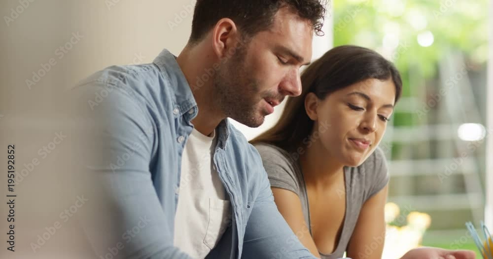 4K Attractive couple relaxing at home & browsing the internet together. Slow motion. 4K Attractive couple relaxing at home & browsing the internet together. Slow motion.