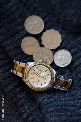 Women's watch with few coins of dollars on wool