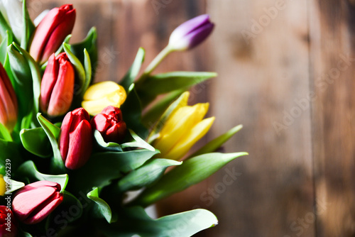 Fototapeta Naklejka Na Ścianę i Meble -  Spring background, postcard: bouquet of multicolored tulips on wooden background.