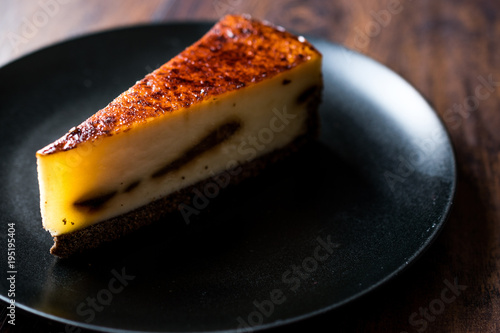 Coffee Cheesecake on Black Plate with Dark Wooden Surface.