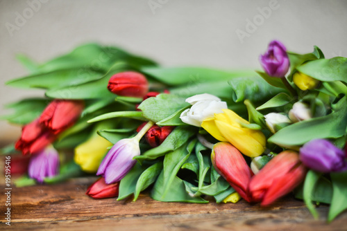 Spring background  postcard  bouquet of multicolored tulips on wooden background.