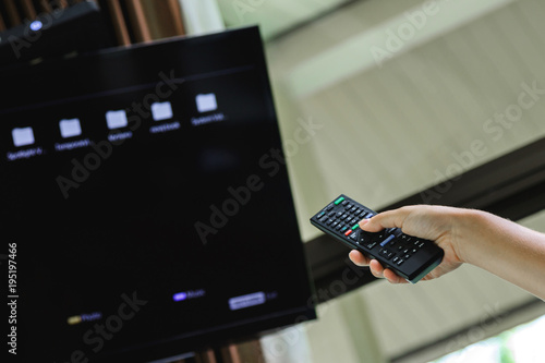 Female hand with TV remote control