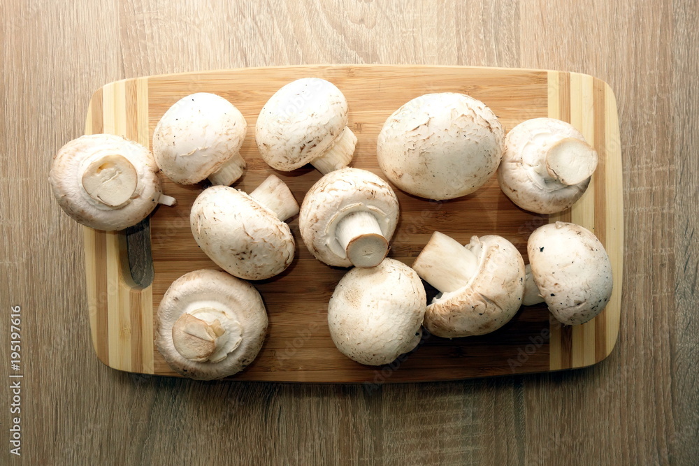 Champignon mushrooms on rustic wooden background, view from overhead Champignon mushrooms on rustic wooden background, view from overhead