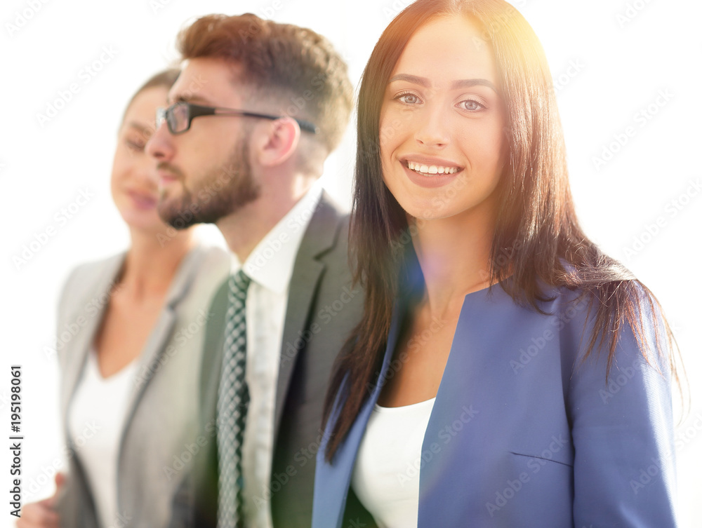 Business woman smiling with her colleagues in the background Business woman smiling with her colleagues in the background