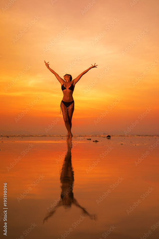 Silhouette of a young and fit woman on the beach at sunset Silhouette of a young and fit woman on the beach at sunset
