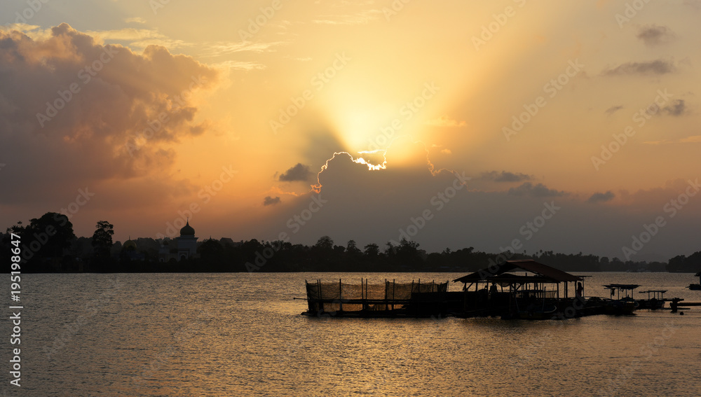 dramatic sunset at sungai Terenganu river with silhouettes of traditional fishermen houses and boats in Kuala Terengganu, Malaysia