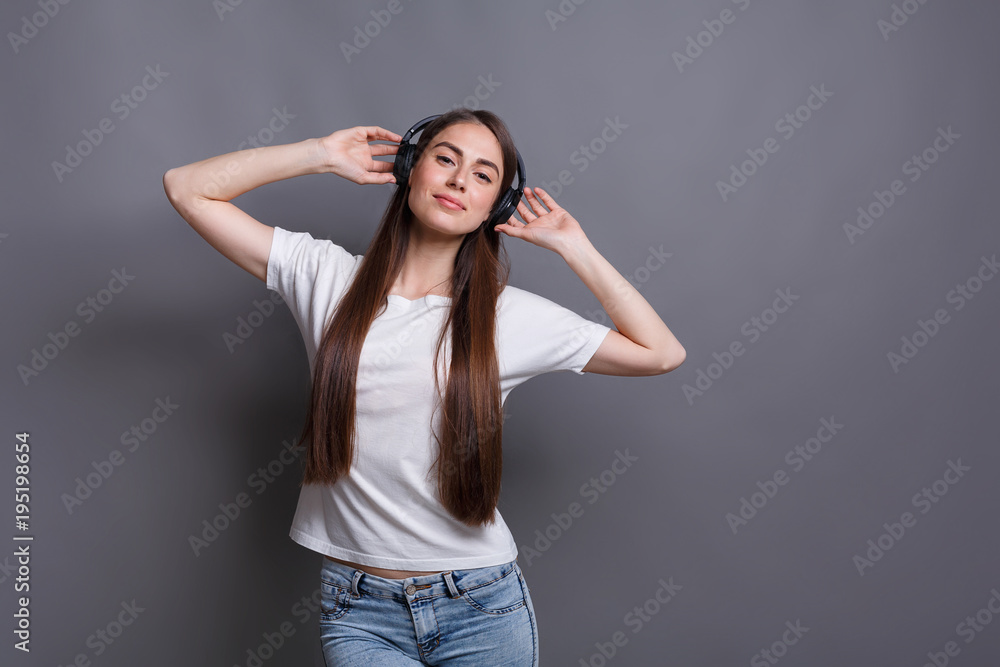 Woman listene to music in earphones, studio shot