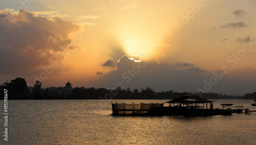 dramatic sunset at sungai Terenganu river with silhouettes of traditional fishermen houses and boats in Kuala Terengganu, Malaysia photo