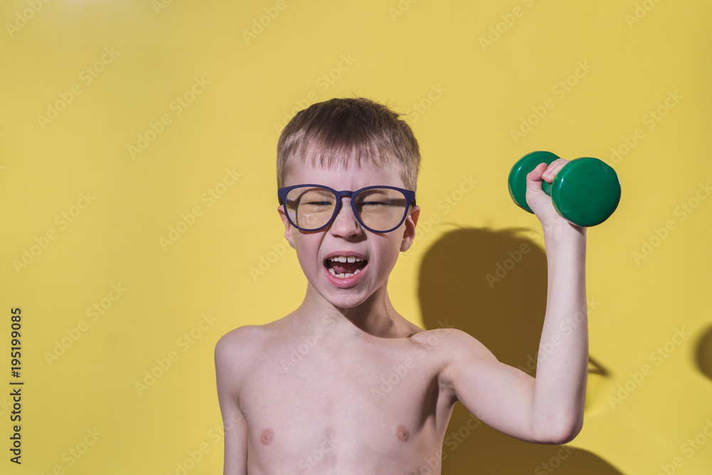 Small boy in glasses holding dumbbell in hand. Child's face feeling very  heavy. Funny sport concept. Stock Photo | Adobe Stock