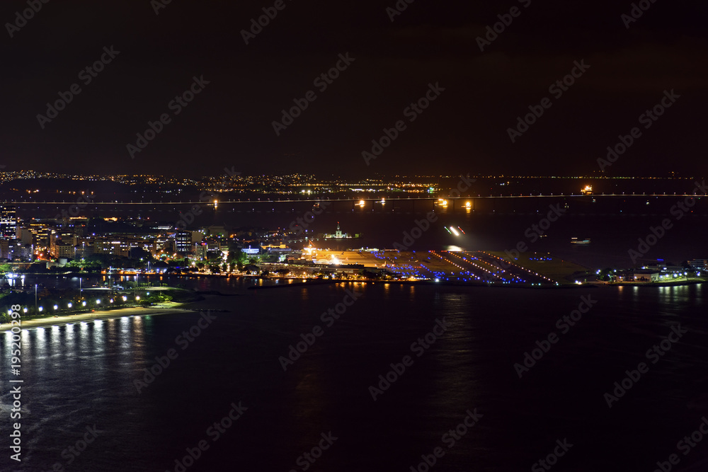 Night view of the top of the Santos Dumont airport at downtown of Rio de Janeiro with lights, buildings and Rio Niteroi bridge at background