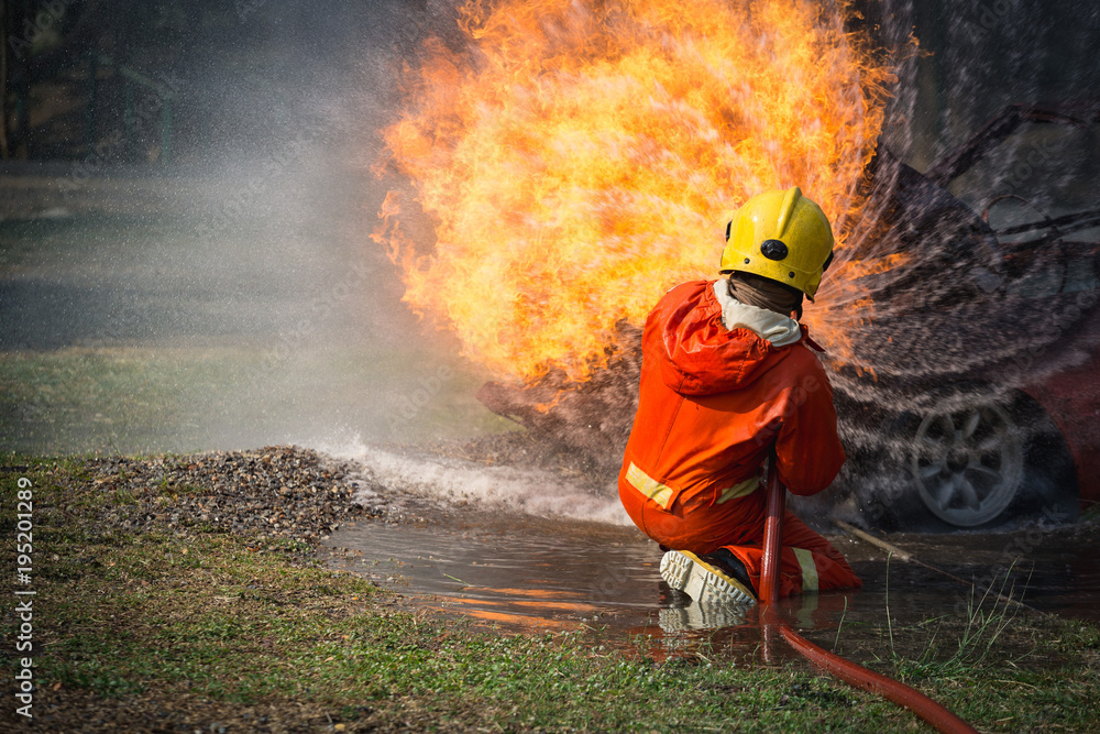 Obraz premium Firefighters training, Team practice to fighting with fire in emergency situation..Spray twist water to the flame