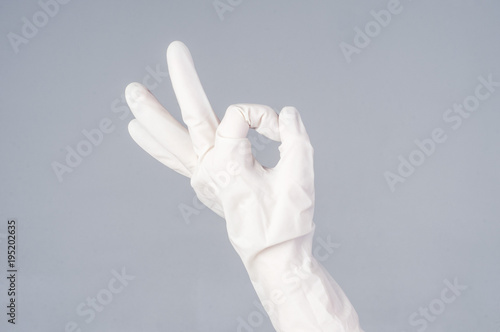 Male hand in latex glove. OK sign. on dark background