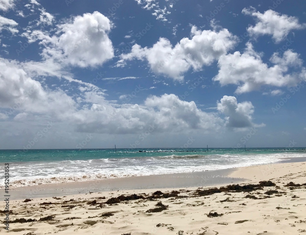 Idyllic and beautiful beach in Barbados (Caribbean island): Nobody, white sand, turquoise water, waves and white clouds