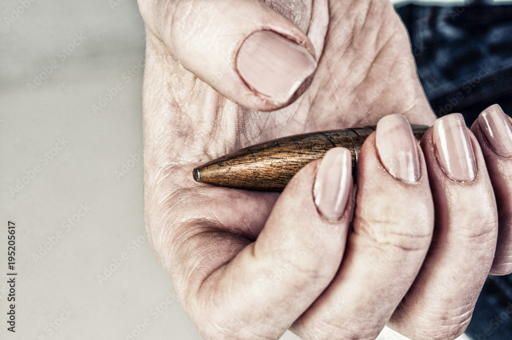 Obraz premium Conceptual photography against the war. A big bullet in the hands of a girl.