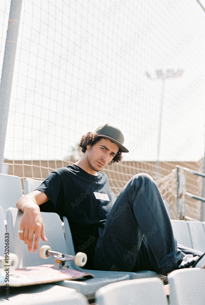 Man with board posing on stadium chairs Man with board posing on stadium chairs