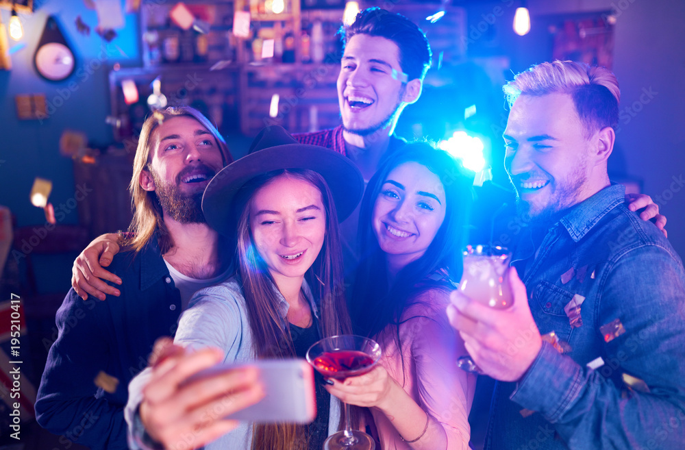 Selfie Time. Young Group of Friends Partying In A Nightclub And Toasting Drinks. Happy Young People With Cocktails At Pub. The People Have A Great Mood And They Smile A Lot.