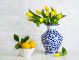 Yellow tulips in the chinese vase and lemons in the bowl