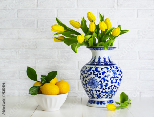 Fototapeta Naklejka Na Ścianę i Meble -  Yellow tulips in the chinese vase and lemons in the bowl