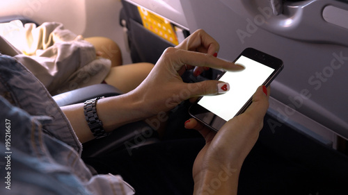 touching and zoom mobile phone screen on airplane or aircraft,blank mobile phone screen mock up,selective focus